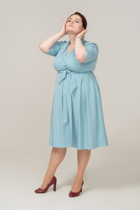 一个穿着蓝色裙子摆姿势的女人的前视图