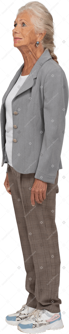 Old lady in suit standing in profile and looking up