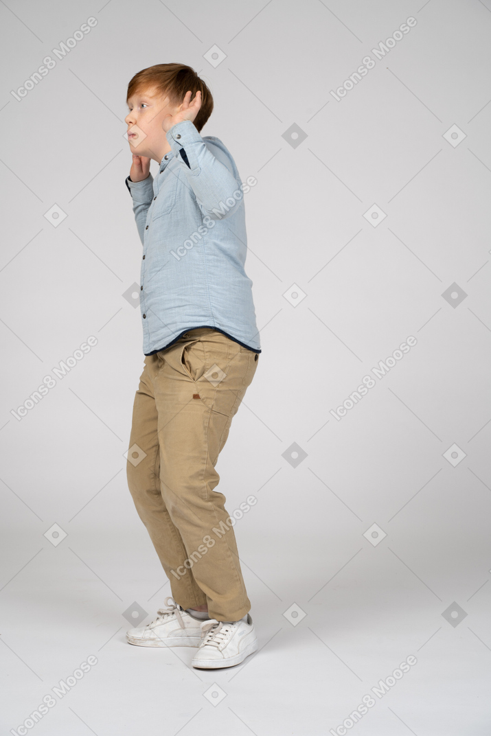 A young boy raising his hands