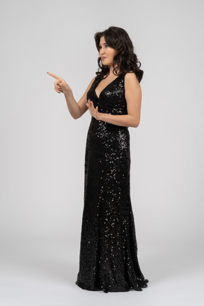 Woman in black evening dress pointing to something
