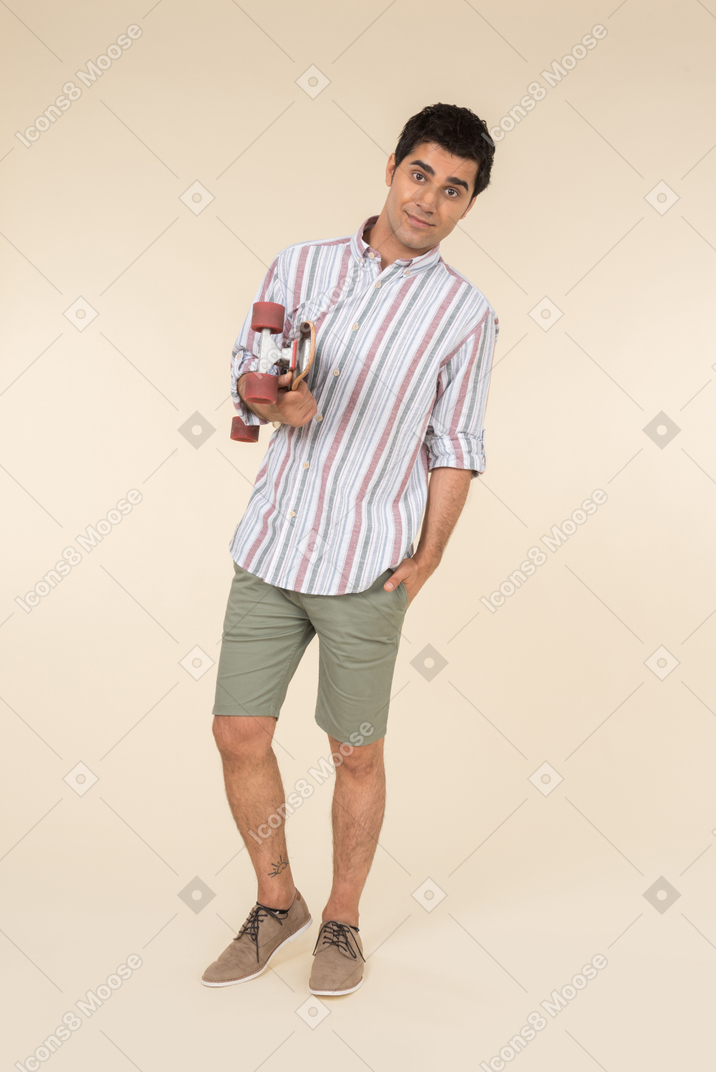 Young caucasian guy holding skate