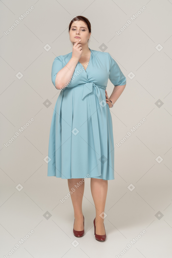 Женщина в синем платье думает о чем-то, вид спереди