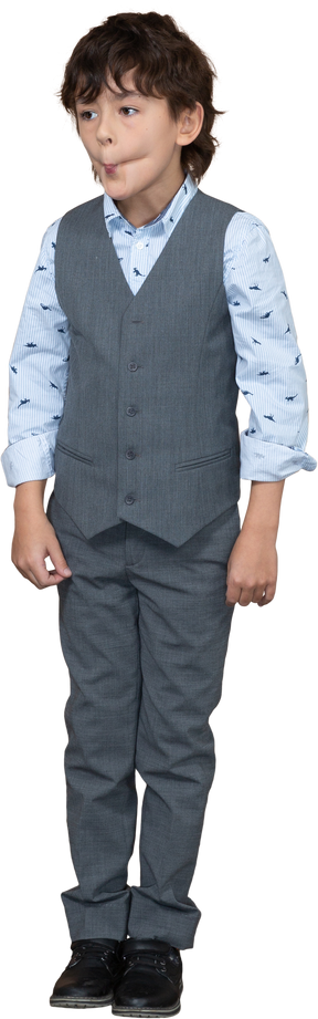 Front view of a cute boy in suit making faces