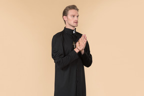 Catholic priest praying using prayer beads