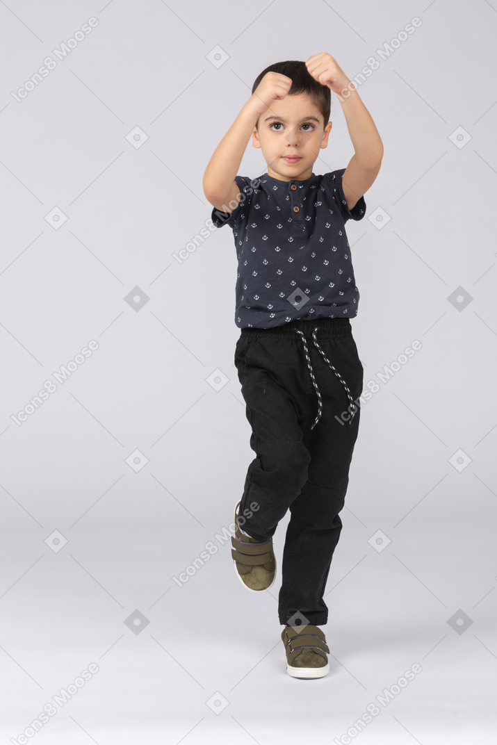Front view of a cute boy standing on one leg
