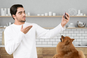 Young man taking a selfie in front of his dog