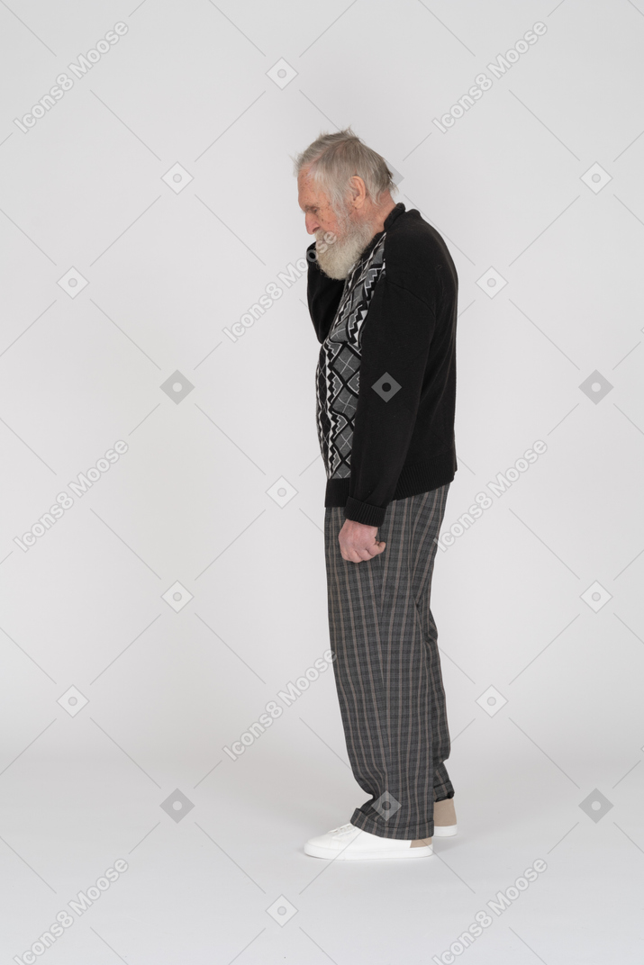 Side view of an old man scratching his head and looking down
