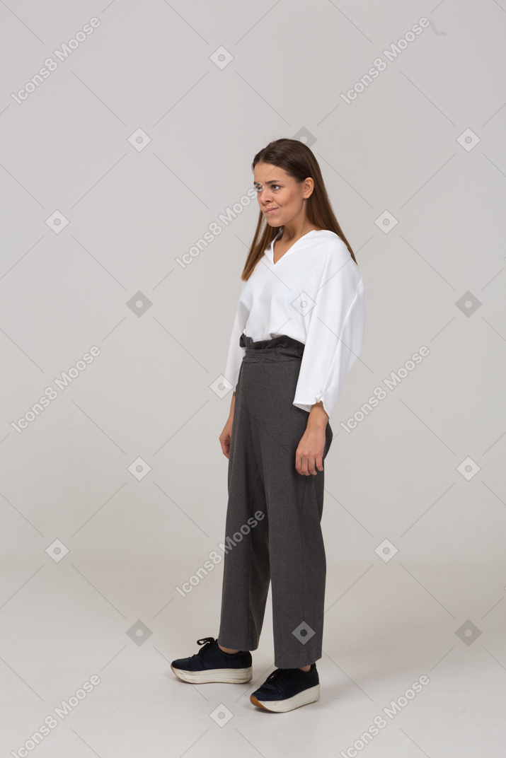 Three-quarter view of a smirking young lady in office clothing looking aside