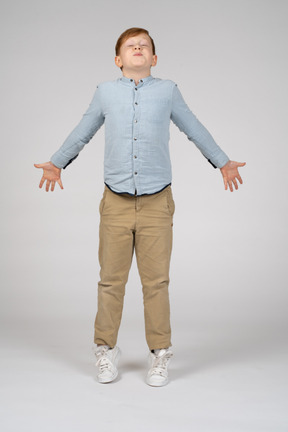 Front view of a boy jumping with his arms outstretched