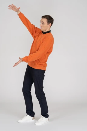 Young man in orange sweatshirt standing