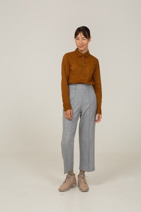 Front view of a winking young asian female in breeches and blouse