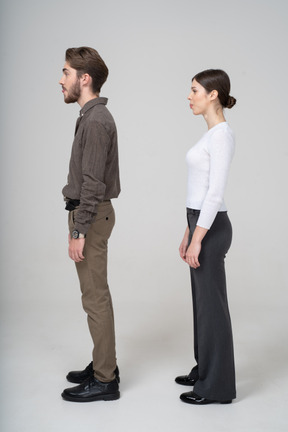 Vue latérale d'un jeune couple en vêtements de bureau montrant une petite langue