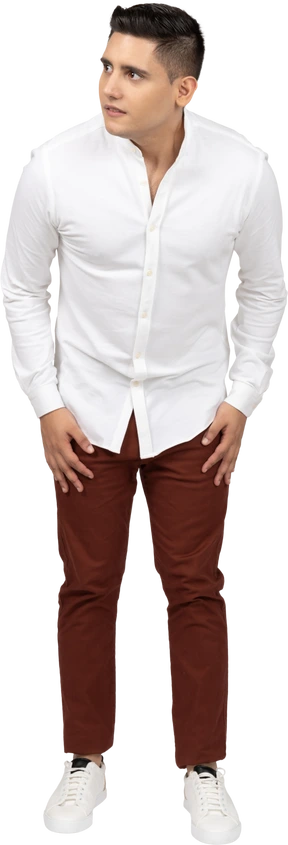 Front view of a young latino man leaning forward slightly and cautiously
