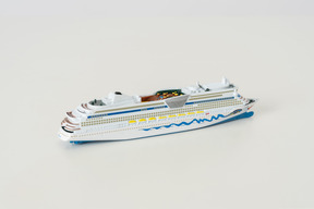The toy cruise ship on the light grey background