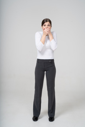 Front view of a young woman covering mouth with hands