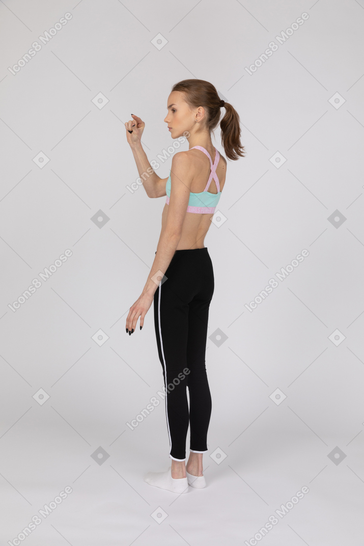 Una adolescente en ropa deportiva mostrando el tamaño pequeño de algo.
