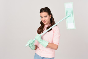 Attractive young woman holding a mop