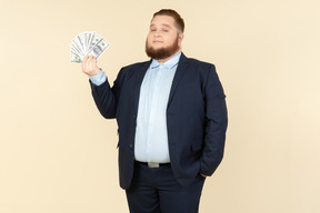 A plus-size man in a black costume with dollar bills in his hands