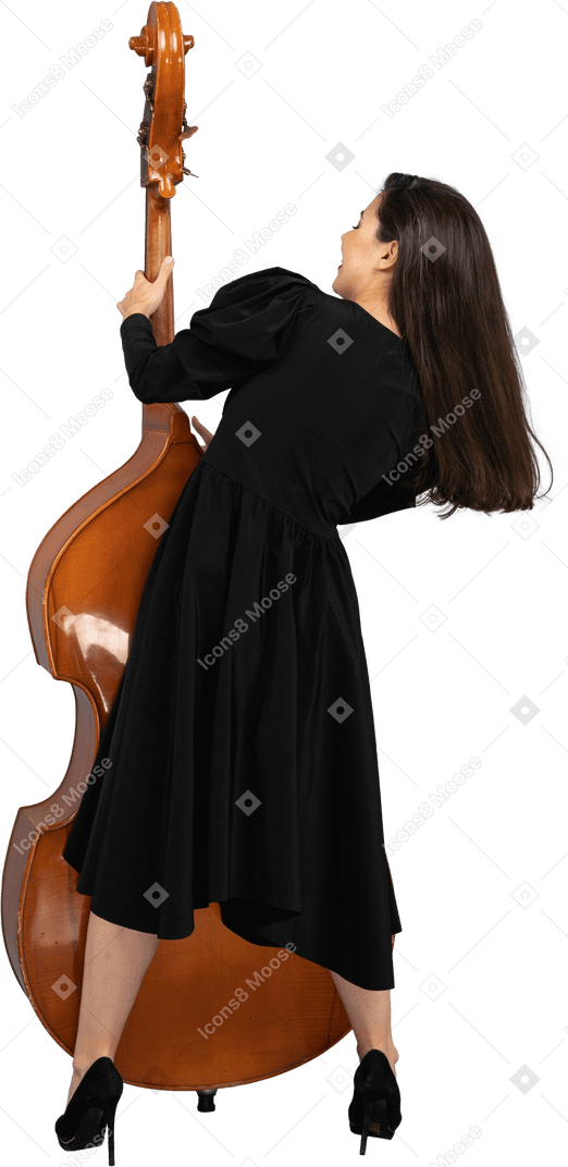 Vista de trás de uma jovem musicista vestida de preto segurando seu contrabaixo