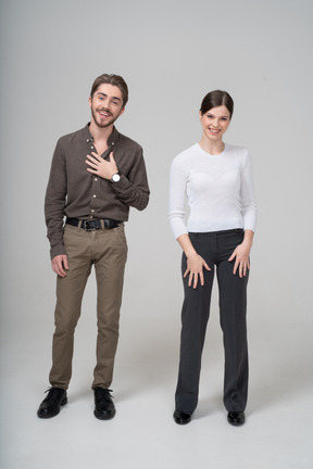 Vista frontal de una joven pareja riendo en ropa de oficina