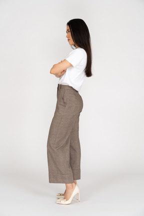 Side view of a young woman in breeches crossing hands