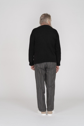 Back view of an old man standing and turning head