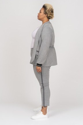 Dark skinned female in grey sport suit posing in profile