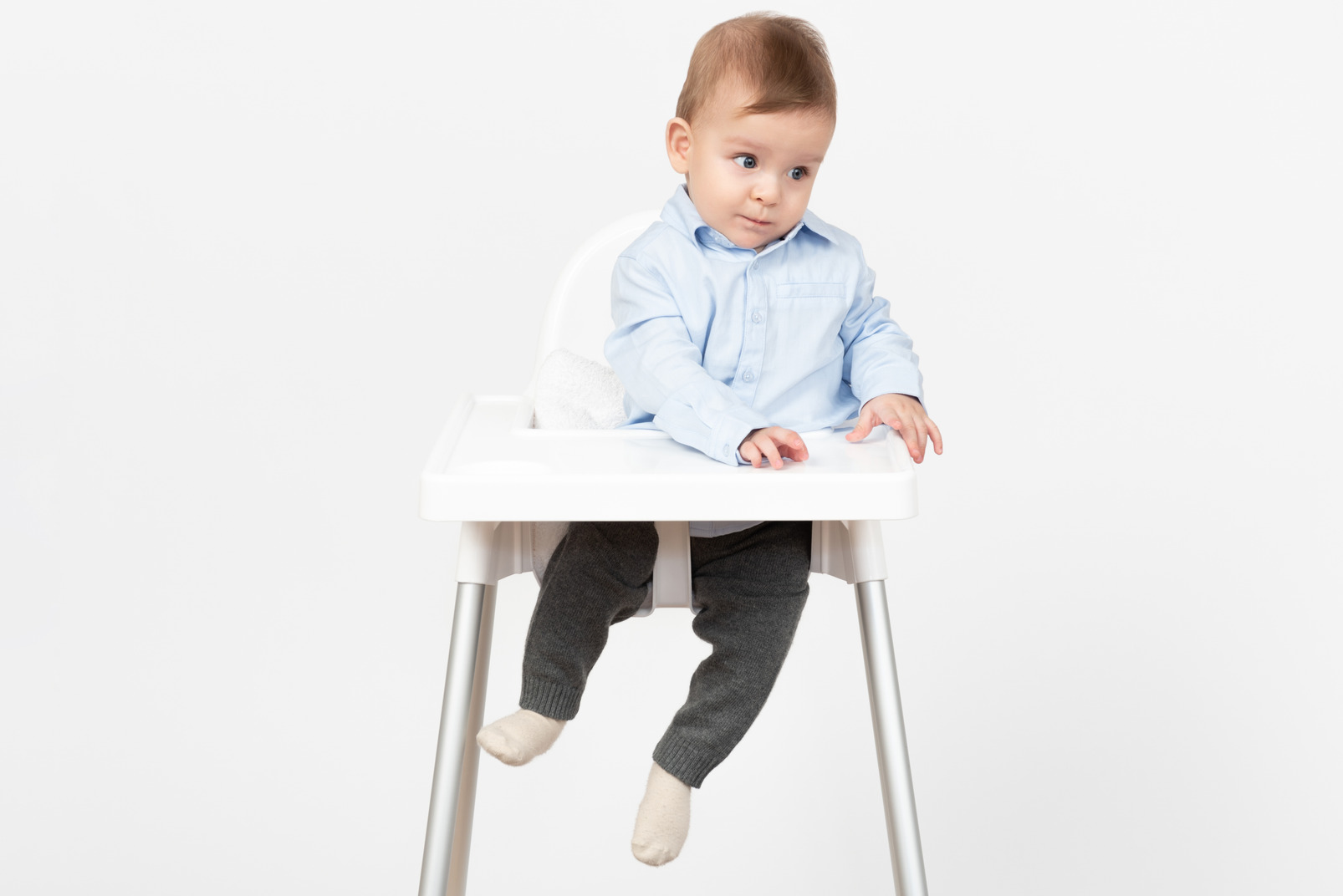 Adorable little baby boy sitting in highchair