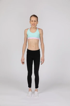 Vista frontal de una adolescente estornudando en ropa deportiva.