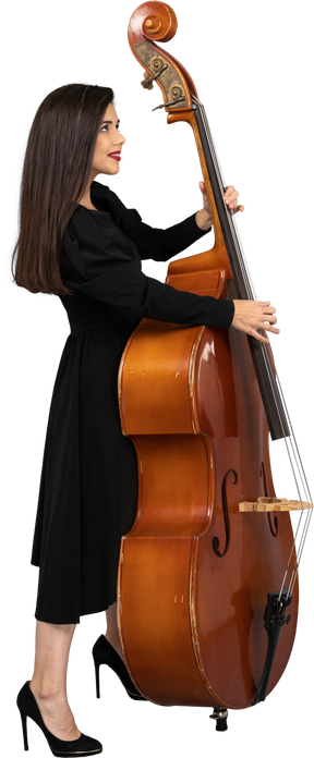 Vista lateral de uma jovem musicista vestida de preto segurando seu contrabaixo