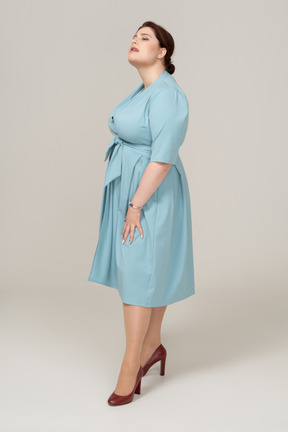 Vista frontale di una donna in abito blu che guarda in alto