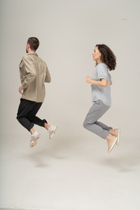 Vue latérale d'une jeune femme et d'un homme en l'air avec les jambes pliées