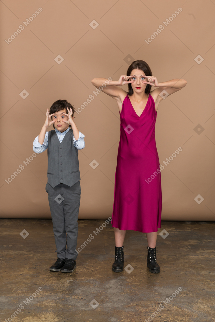 Vista frontal del niño y la mujer con estilo abriendo los ojos