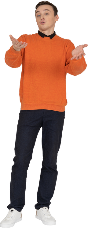 Молодой человек в оранжевой кофте стоит