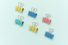 Colourful paper clips on blue background