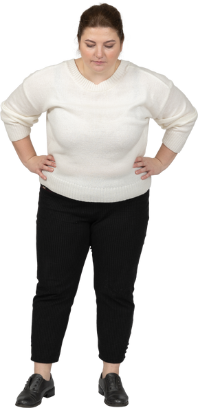 Front view of a plump woman in casual clothes standing with hands on hips