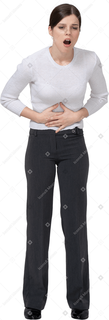 Vista frontale di una giovane donna in abiti da ufficio che tocca lo stomaco