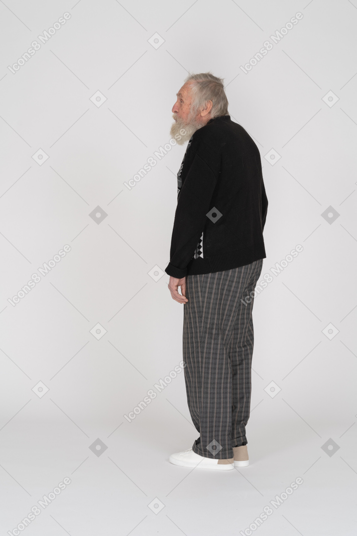 Пожилой мужчина стоит боком