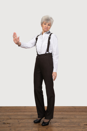 Three-quarter view of a refusing old lady in office clothing
