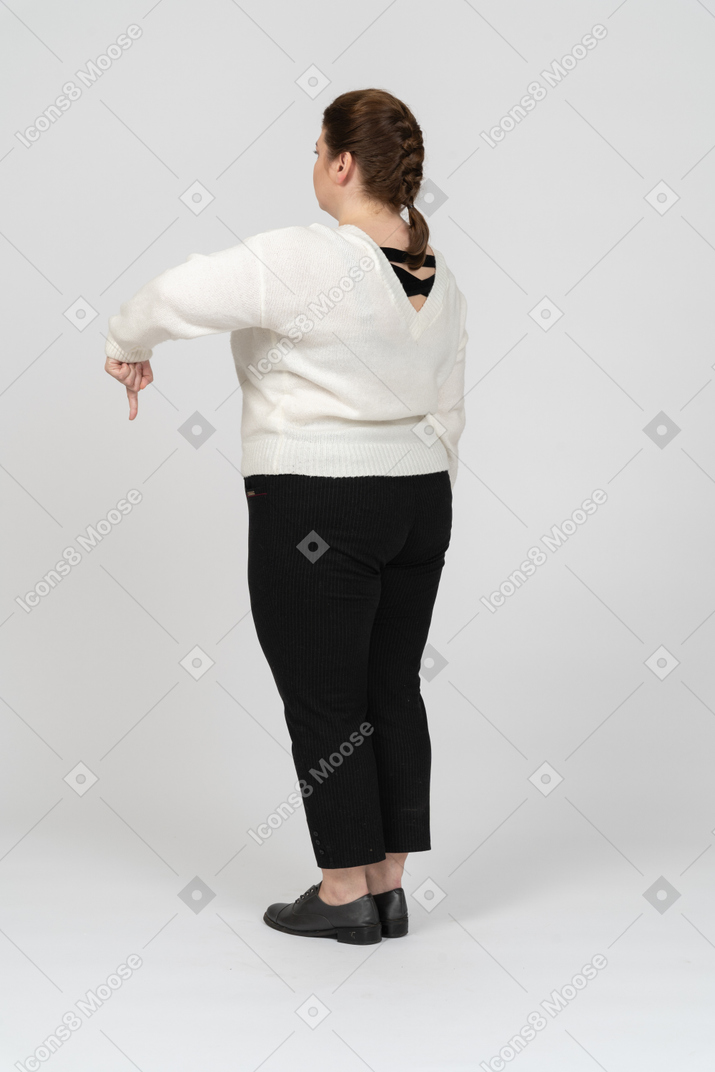 Plump woman in casual clothes pointing down