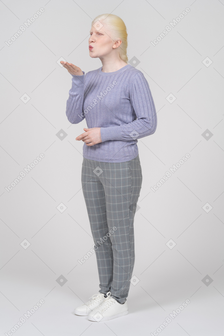 Woman in casual clothes blowing a kiss