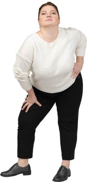 Plump woman in white sweater posing