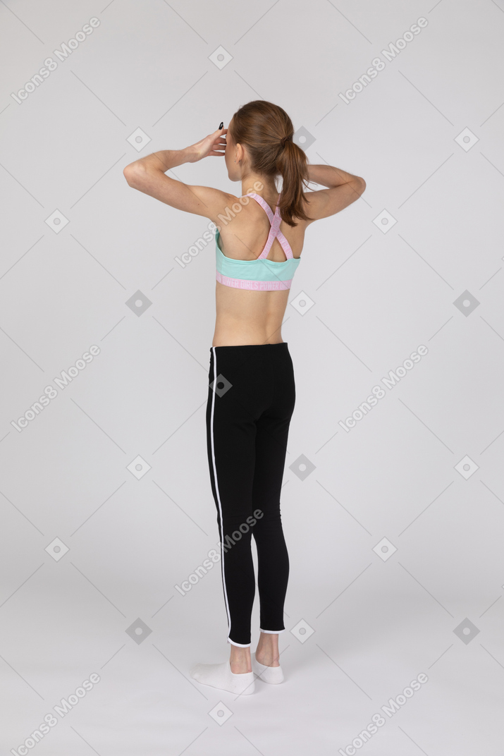 Teen girl in sportswear covering eyes with hands