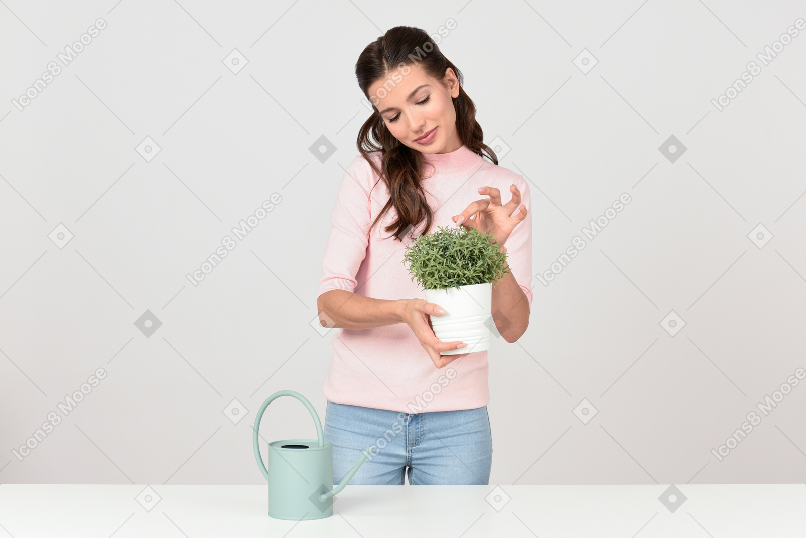 Atractiva joven cuidando una planta de interior.