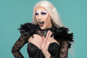 Friendly dragqueen looking aside waving hand