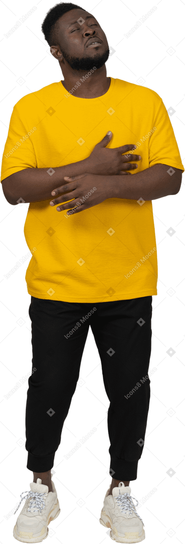 Vista frontal de um jovem de pele escura em uma camiseta amarela de mãos dadas na barriga