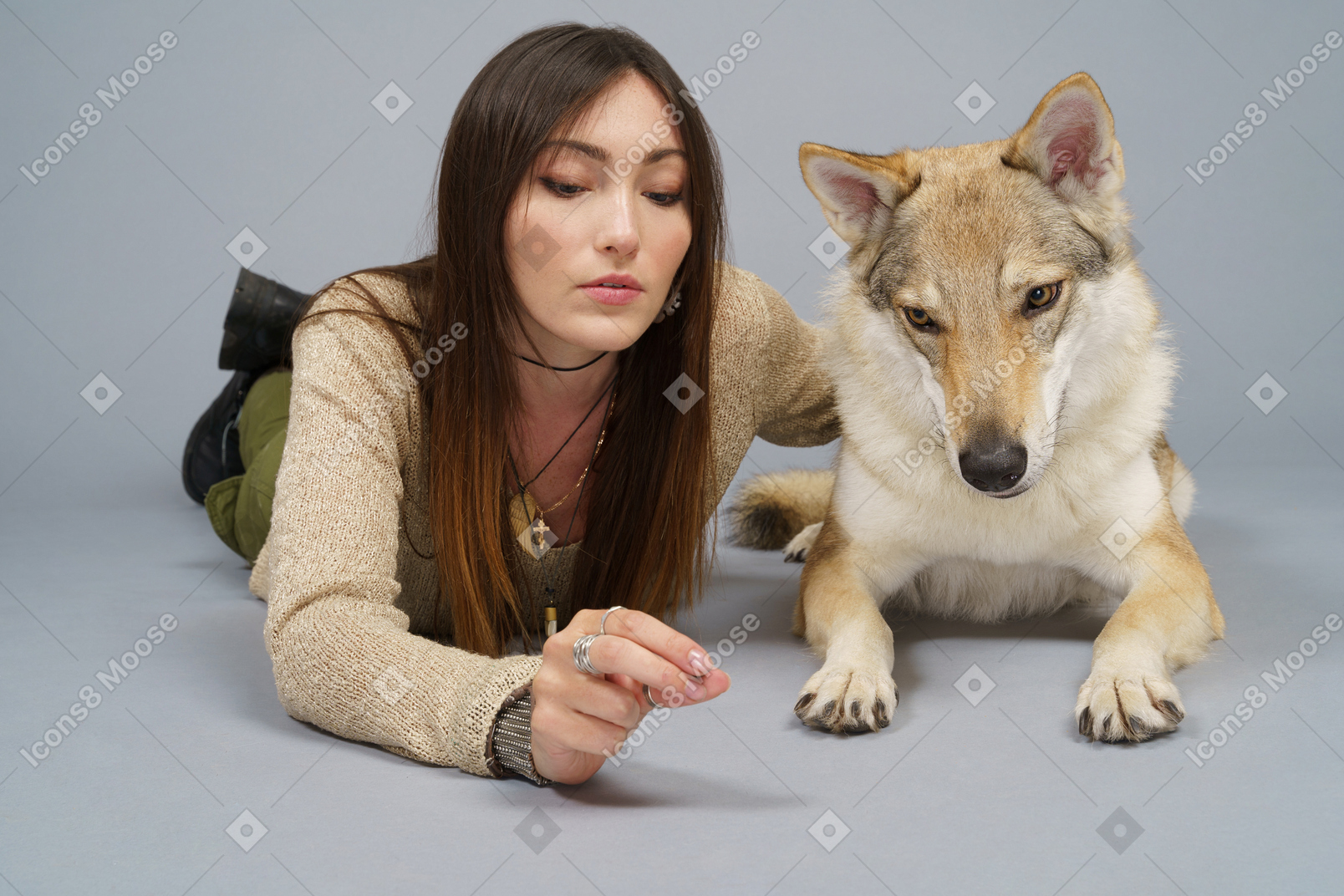 De cuerpo entero de una maestra acostada junto a su perro y mirando a la cámara