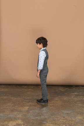 Boy in suit standing in profile