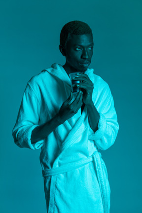 흰색 목욕 가운을 입은 젊은 흑인 남자