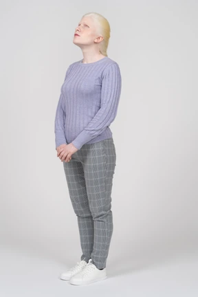 Young woman in casual clothes looking upwards